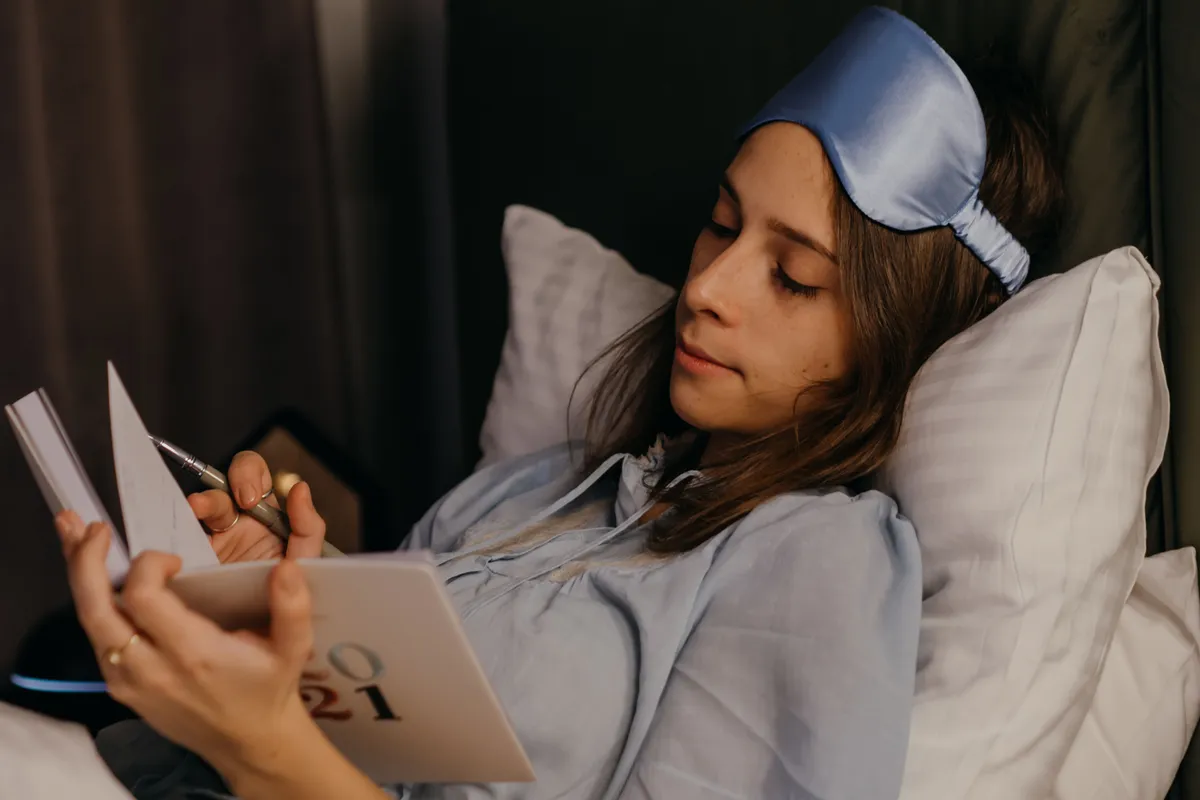 Persona escribiendo un diario de sueños al despertar