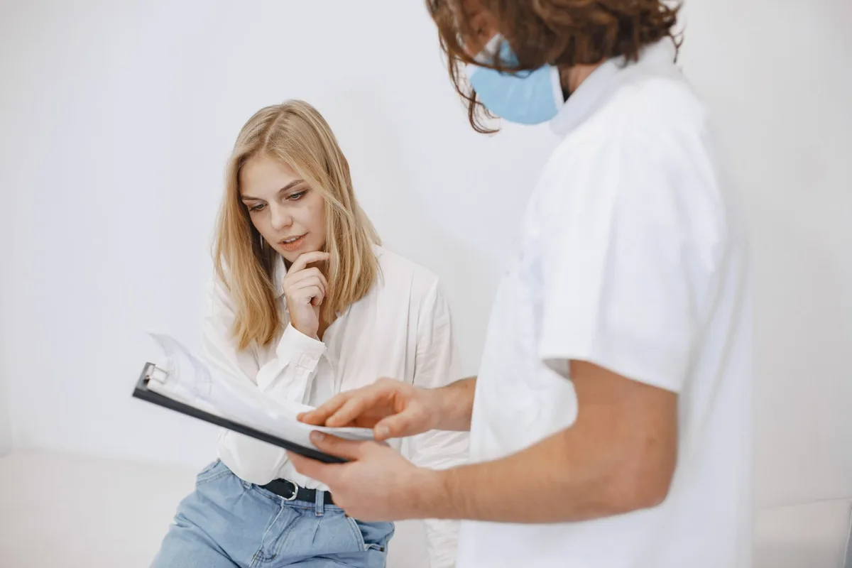 Profesional sanitario revisando un informe médico con una paciente en la consulta